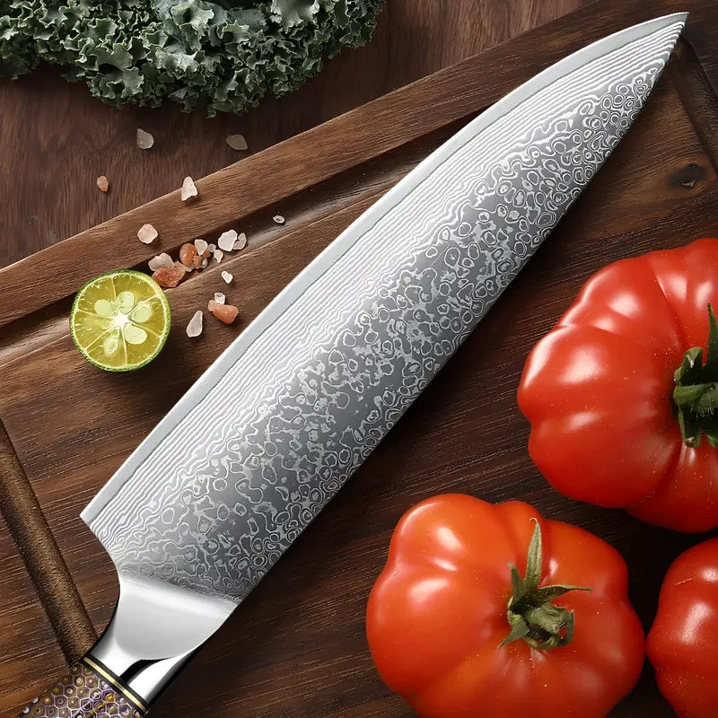 Gyuto Chef Collector présenté avec tomates, citrons et herbes fraîches, lame damassée bien visible.