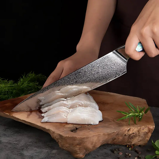 Le Gyuto Lame Céleste utilisé pour trancher un filet de poisson, mettant en valeur sa lame damassée fine et tranchante.