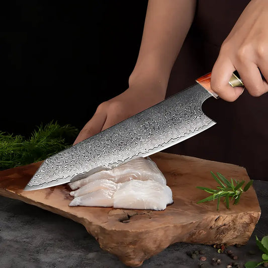 Le couteau Chef du Clan en action pour trancher du poulet sur planche, lame longue et fine en damas.