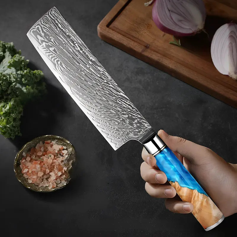 Couteau Nakiri Ciel de Nara tenu en main lame damassée orientée vers les ingrédients à découper.