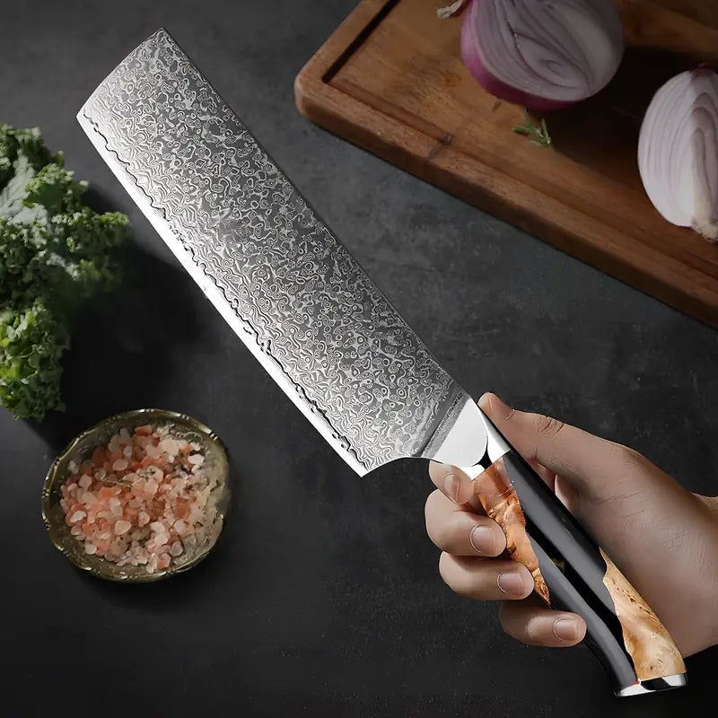 Nakiri Brume de Matsu tenu en main prêt à émincer un oignon sur planche en bois.