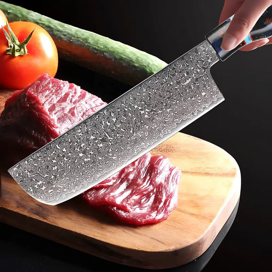 Le Nakiri Murmure de Botan tranche une pièce de viande avec précision sur planche accompagné de légumes frais.