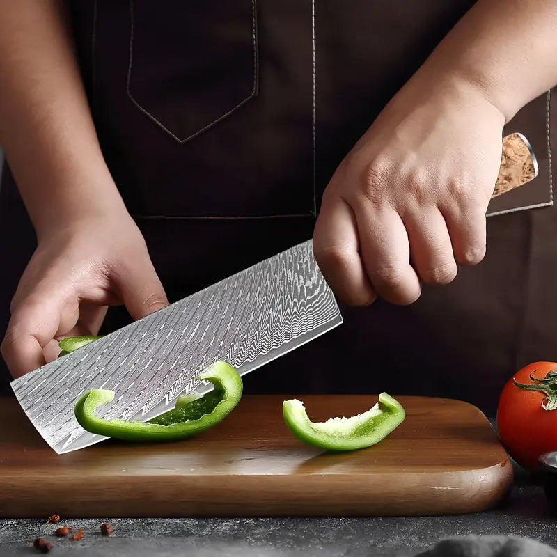 Nakiri Essence de Tsubaki en action tranchant un concombre vert avec efficacité sur planche de cuisine.