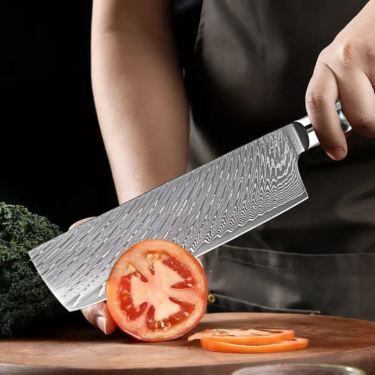 Le Nakiri Essence de Tsubaki en pleine découpe de tomate illustrant sa précision et son tranchant net.