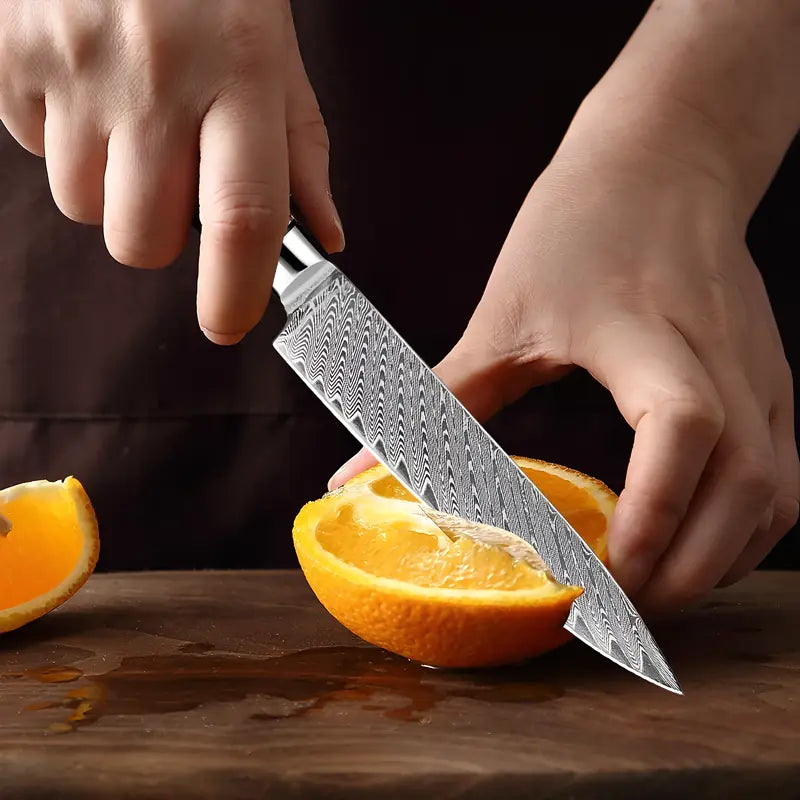 Le couteau d’office Océan de Yami en action, tranchant une orange avec fluidité sur une planche de bois.