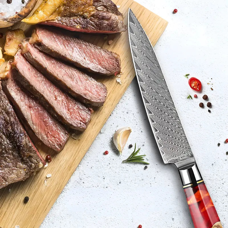 Couteau Petty Flamme de Kyoto présenté avec des tranches de viande et des herbes fraîches prêt à servir.