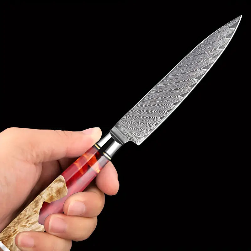 Petty Flamme de Kyoto tenu en main mettant en valeur le manche rouge brillant et la lame fine.