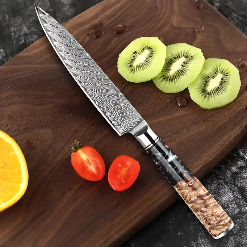 Couteau d’office Lame du Bushido sur une planche en bois, entouré de kiwi, tomate cerise et orange fraîchement découpés.