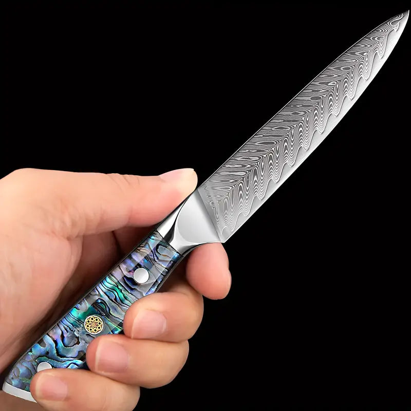 Lame Céleste tenue en main, montrant le détail du manche nacré et la finesse de la lame damassée.