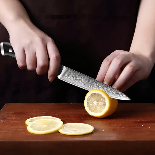 Le Petty Lame du Gardien en pleine découpe nette de rondelles de citron sur planche de bois.
