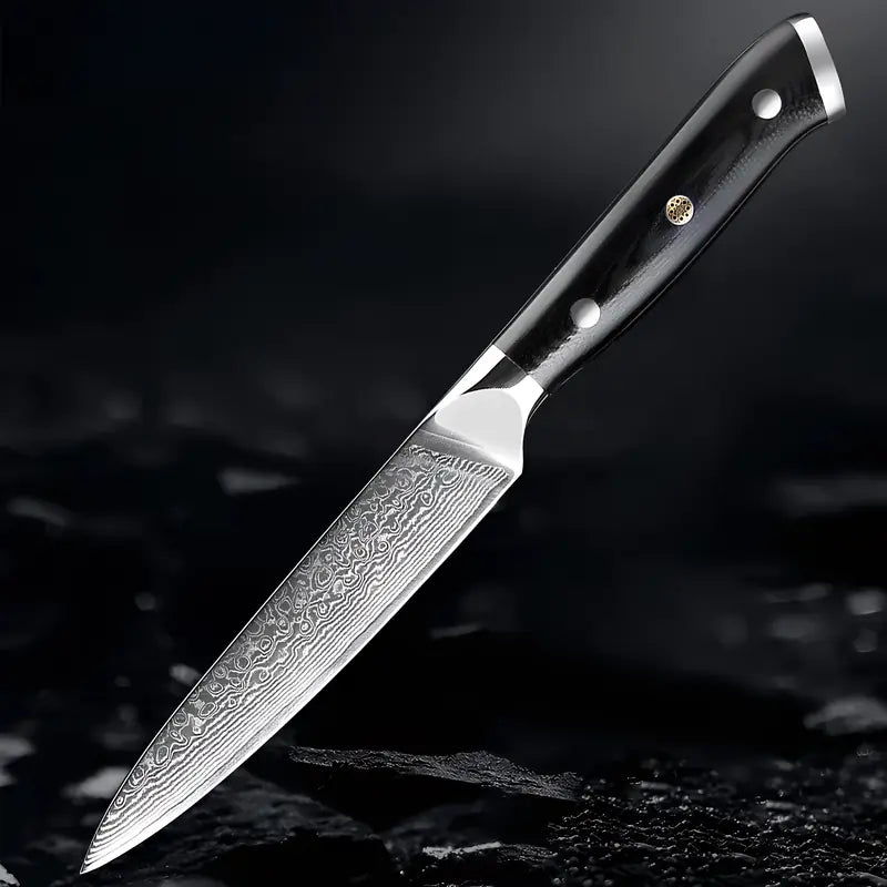 Couteau Petty Lame du Gardien posé sur surface sombre humide mettant en valeur la lame damassée et le design sobre.