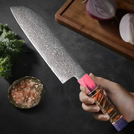 Couteau Santoku en acier damas 67 couches à côté d’ingrédients frais sur une planche.