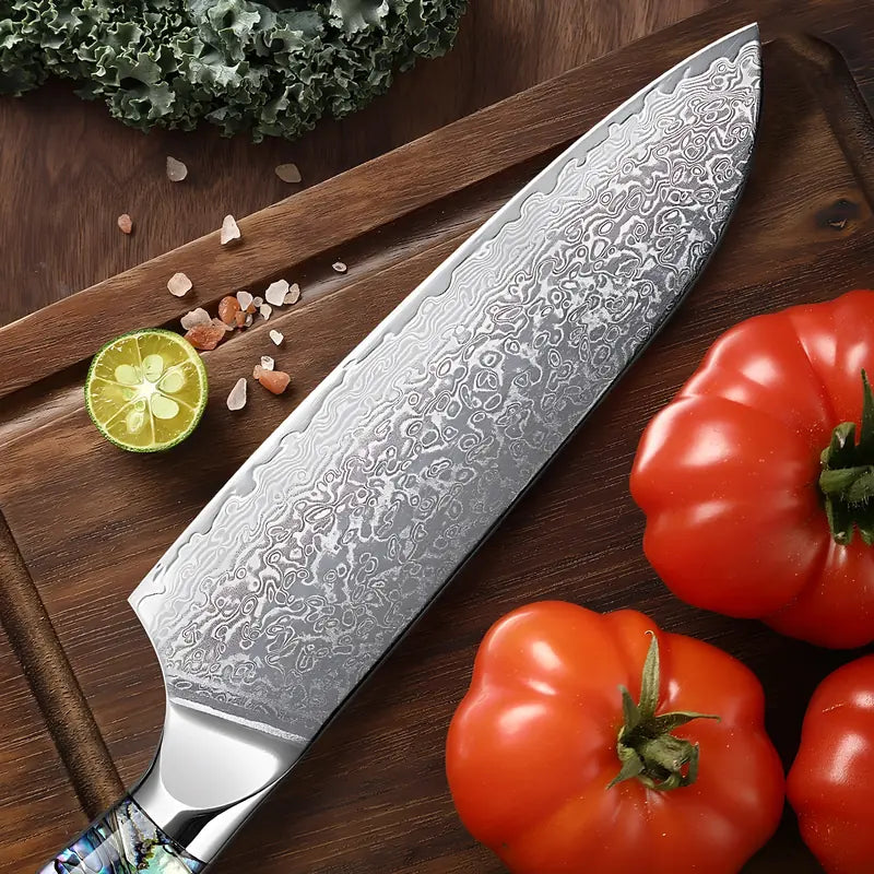 Le couteau Santoku repose sur une planche entourée de légumes, mettant en valeur sa lame damassée.