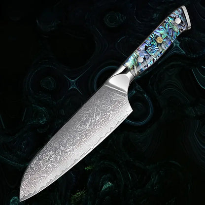Un couteau Santoku est mis en lumière sur fond noir, soulignant les détails de sa lame damas 67 couches.