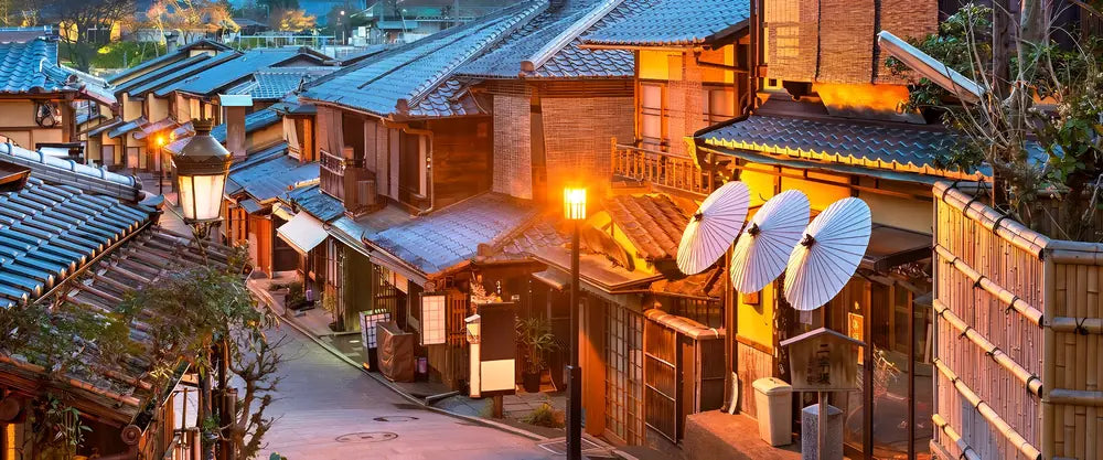 Scène de rue au Japon la nuit, illuminée par des lanternes et enseignes traditionnelles.